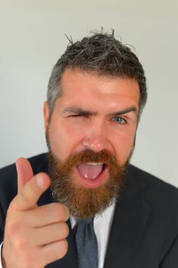 Siyah takım elbiseli kızıl sakallı adam.