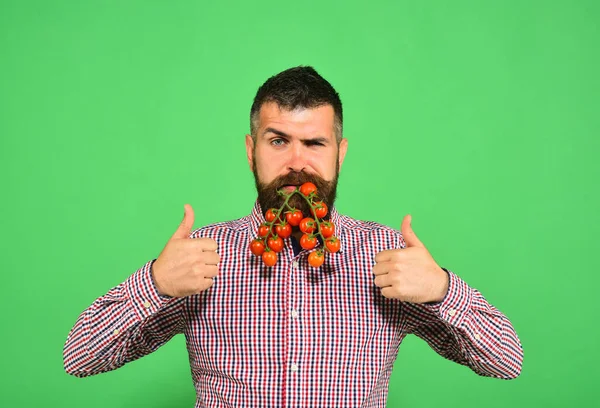 Jordbrukare med självsäkert ansikte håller en massa röda körsbärstomater. — Stockfoto