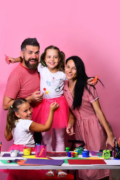Artistas abrazos familiares sobre fondo rosa. Creatividad y concepto familiar —  Fotos de Stock