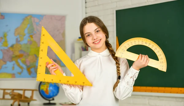 Klein kind met heerser voor wiskundeles. Wiskunde is belangrijk. Schattig klein schoolmeisje met geometrisch gereedschap voor wiskunde. Wetenschap en Technologie. Wiskunde of wiskunde van de basisschool — Stockfoto