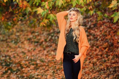 Sonbaharda giymek için rahat kıyafetler. Sevimli sarışın kız, sıcacık ve rahat bir elbise içinde sonbahar arka planında poz veriyor. Hafta sonu için samimi kıyafet fikirleri. Kadın gün batımında yürüyor. Rahat kıyafet.