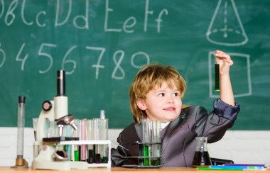 Gelecek için öğren. Biyoloji bilimi. Sonuç. Tıbbi konsept. Küçük dahi çocuk. Küçük çocuk okulda mikroskop kullanıyor. Araştırma için sıvıyla test tüpleri. Küçük çocuk. Okuldan ders.