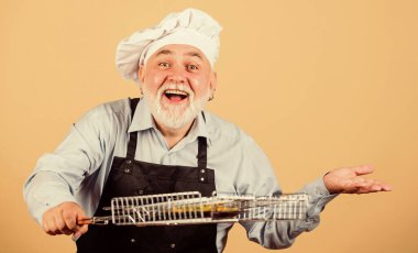 Barbekü için mutfak aletleri. Piknik ve barbekü konsepti. Izgara tarifi. Aile hafta sonu. Olgun sakallı şef ızgara ızgara ızgarası tutar. Lezzetli ve lezzetli. Izgara yemek. Sağlıklı beslenme şekli