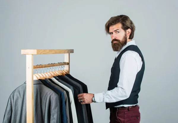 Man in custom tailored suit presenting expensive tailored tuxedo. Man in boutique. Man with suit. tailor in his workshop. Handsome bearded fashion man in classical costume suit. Tailor at work — Stock Photo, Image