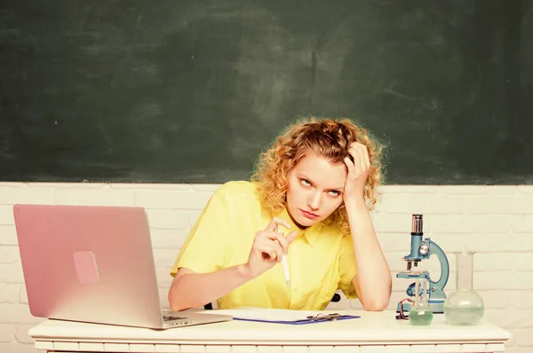 Make notes about chemistry research results. girl in classroom laboratory with computer. upset student with microscope beaker. biology experiment. scientist teacher at school lab. hard working day — Stock Photo, Image