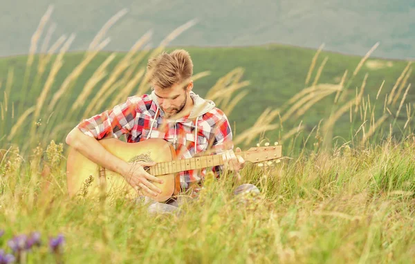 Stellen Sie sich der Musik. Akustikgitarrist. Countrymusik. sexy Mann mit Gitarre im karierten Hemd. Hipster-Mode. Westerncamping und Wandern. glücklich und frei. Cowboy-Mann spielt Gitarre im Freien — Stockfoto