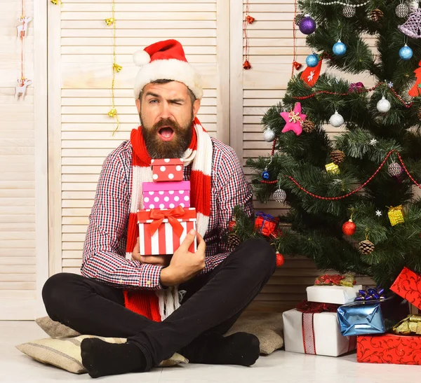 Guy in cappello e sciarpa da albero di Natale e regali — Foto Stock