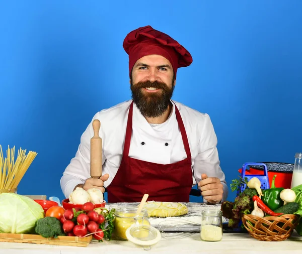 Man med skägg sitter vid bänkskivan på blå bakgrund — Stockfoto