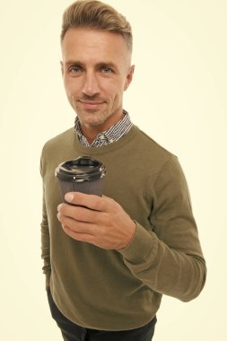 Sabah kapuçinosu. Adam kahveyi götürmeyi tercih ediyor. Olgun bir adamın elinde kağıt kahve fincanı beyaz arka planda durur. Kahve içen sıradan bir adam. Lezzetli taze kahve konsepti. Kafeinle kendimi iyi hissediyorum.