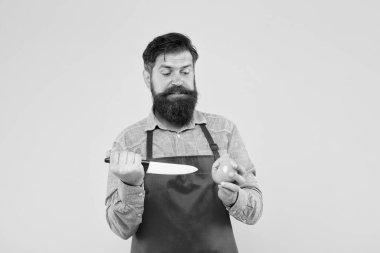 Şef yemek hazırlıyor. Yemek pişirmek onun hobisi. Aşçı üniformalı sakallı adam. Kendine güvenen hizmetçi domates hazırlar. Olgun adam elinde bıçak ve sebze tutuyor. Taze salata yapıyorum. Kırmızı önlüklü profesyonel şef.