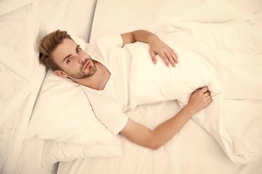 Sabahın erken saatlerinde baş ağrısına neden olur. Migren ağrısı. Uyku problemleri sabahları baş ağrılarına yol açabilir. Yatakta dinlenen yakışıklı adam. Horlamak baş ağrısını artırabilir. Uyku apnesinin yaygın belirtisi.
