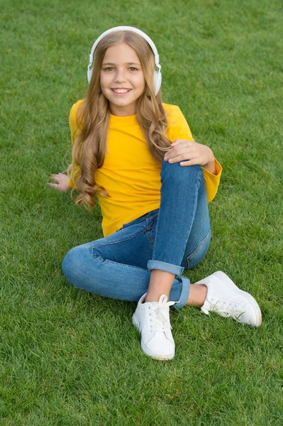 Cute smiling girl modern headphones enjoy music relaxing outdoors, musical taste concept — Stock Photo, Image