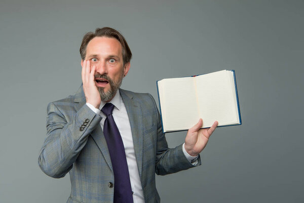 businessman surprised by interesting information in book. get ready for business training. successful man in business suit hold notebook. planning and success concept. feel the surprise