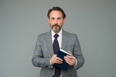 İlerici bir yaklaşım. Planlama ve başarı. Kitap okuyorum. İş adamı kitapta ilginç bilgiler bulur. İş eğitimine hazır olun. İş elbisesi içinde başarılı bir adam günlük defteri tutuyor.