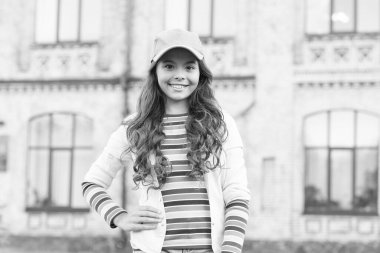 Şapkalı şık bir çocuk. Sıcak ve dostça bir gülümseme. Sağlıklı saç kavramı. Şirin küçük kızın kıvırcık saçları var. Sokaktaki güzel esmer çocuk. Bahar modası ve güzellik. Mutlu Çocuklar Günü