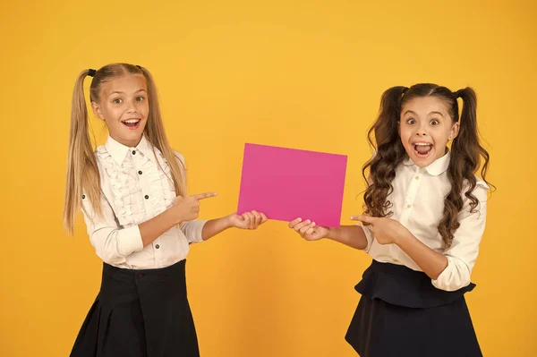 Cartel de uniformes escolares para niñas. Concepto de comunicación visual. Amistad escolar. Las chicas de la escuela muestran cartel. Espacio de copia de póster social. La socialización implica cómo los niños se llevan bien entre sí — Foto de Stock