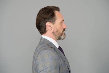 Yakışıklı, olgun, sakallı, takım elbiseli bir adam.