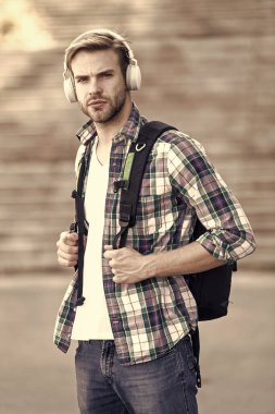 Üniversite öğrencisi kulaklığı ve sırt çantası. Online eğitim. Ses kitabı konsepti. Adam üniversitede okuyor. Öğrenciyim. Okul hayatı. Müziği dinle. Modern ve dijital gençlik. Moda adamı.