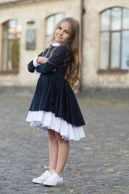 Tarz duygusunu geliştiriyor. Küçük çocuk dışarıda üniforma giyiyor. Okul tarzına geri dön. Giyin, bak. Kıyafet kuralı. Moda tarzı okul kıyafeti. İlkokul eğitimi. 1 Eylül. Havalı ve şık görünüyorsun.