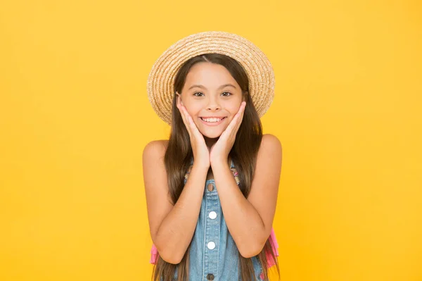 Moments of happiness. small child on yellow background. holiday joy and activity. beauty. long-awaited summer vacation. happy childhood. cheerful little girl wear straw hat. beach fashion for kids