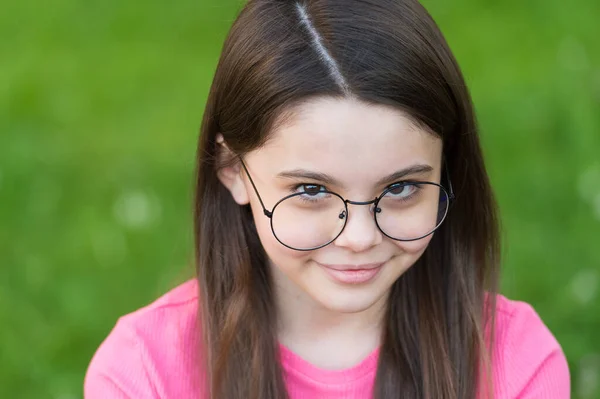 Klein meisje dragen vintage velg bril groen gazon achtergrond, verlegen baby concept — Stockfoto