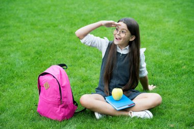 Görüş için yiyecek. Mutlu çocuk yeşil çimlere bakar. Okul yemeği. Görme ve göz kontrolü. Göz koruyucu. Göz sağlığı eğitimi. Pediatrik göz doktoru. Görüşü doğal olarak geliştir