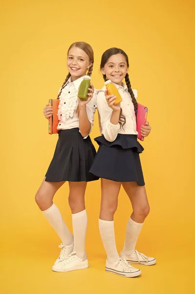 Diary and dairy. lunch time. small girls with book. read and write. happy girls study with notepad at lesson. back to school. Pupils drink juice at library. healthy food. Having healthy breakfast — Stock Photo, Image