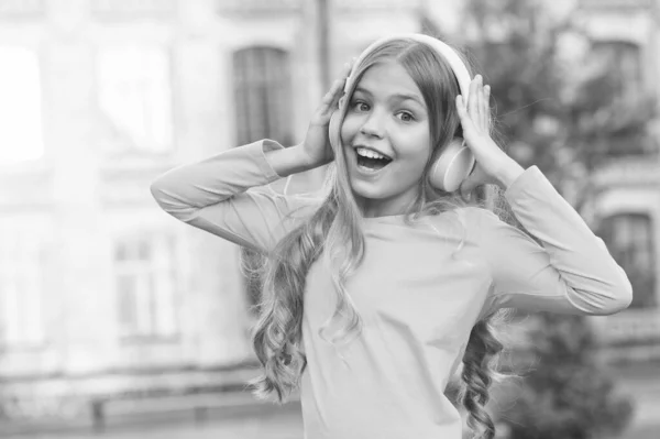 Mädchen hören Musik modernes Gadget. Kind glücklich mit drahtlosem Headset im Freien Sonnenuntergang städtischen Hintergrund. Stereo Kopfhörer. Kind mit moderner Technologie. Modernes Kind. Musikkanal. Musik für die Seele — Stockfoto