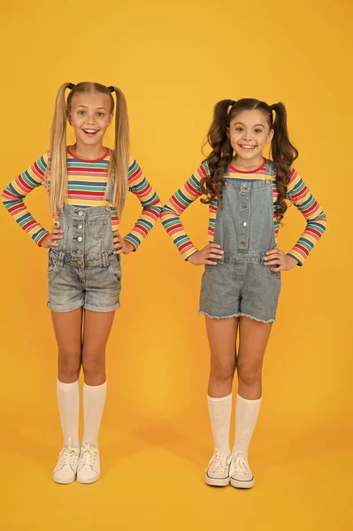 Des couleurs vibrantes. La mode moderne. Mode pour enfants. Les filles cheveux longs. Enfants mignons mêmes tenues. Des petites filles portant des vêtements arc-en-ciel. Des tenues assorties. Tendance et fantaisie. Boutique de mode. Doit avoir accessoire — Photo