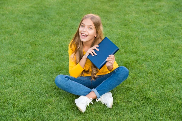 Chica leyendo libro al aire libre césped verde fondo, concepto de hobby intelectual — Foto de Stock