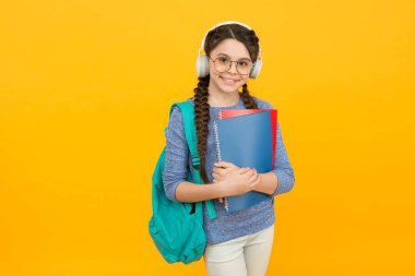 Sırt çantası ve okul gereçleri ile modern öğrenci kız sarı arka plan, evde eğitim kavramı
