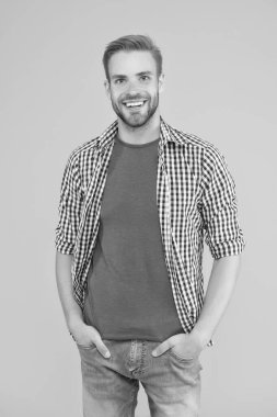 Merhaba yakışıklı. Yakışıklı adam sarı arka planda gülümsüyor. Tıraşsız adamın yakışıklı görünüşü. Sıradan bir tarz. Moda trendleri. Erkekler tımar ediliyor. Cilt rutini. Berber dükkanı. Mutlu ve yakışıklı.