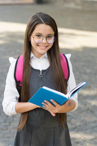Μια βιβλιοθήκη γνώσης. Το χαρούμενο παιδί κρατάει το σχολικό βιβλίο. Αναγνώστης βιβλιοθηκών έξω. Σχολική βιβλιοθήκη. Ωραίος βιβλιοφάγος. Εκπαίδευση ανάγνωσης και γραφής. Πίσω στο σχολείο. Ημέρα γνώσης. Βιβλιοπώλη. 1η Σεπτεμβρίου — Φωτογραφία Αρχείου