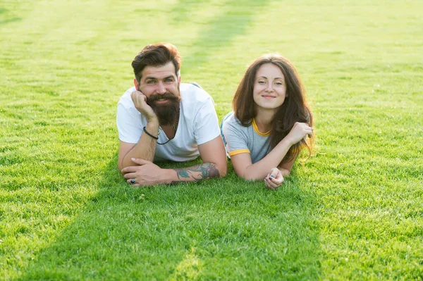 Zorgeloos paar genieten van zonnige dag ontspannen op groene weide, zomer vakantie concept — Stockfoto