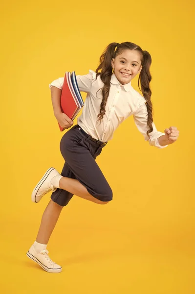 Je retourne à l'école. Enfant joyeux écolière courir. L'élève veut étudier. Enfant actif en mouvement. Je commence la leçon. Continuez. Enfant actif. Dépêche-toi. Une fille avec des livres sur le chemin de l'école. Journée du savoir — Photo