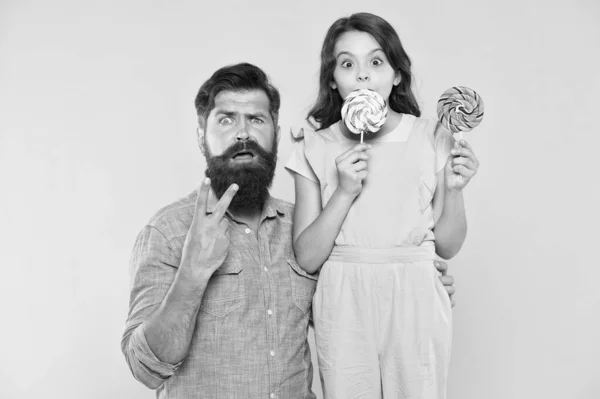 Victoire surprise. Surpris famille fond jaune. Père et fille célèbrent la victoire. L'homme barbu fait signe de victoire. Profiter de friandises sucrées. Victoire ou paix. Amour et confiance. Activités amusantes — Photo