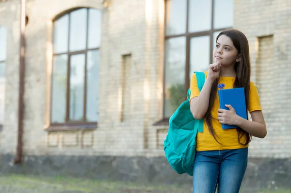 Kleines Mädchen, das draußen denkt. Schulbildung im modernen Leben. zurück zur Schule. Teenager-Mädchen tragen Rucksack. Notizbuch zum Schreiben von Erinnerungen. Kind mit Schulheft. Nachdenkliches Kind hält Buch. Kopierraum — Stockfoto