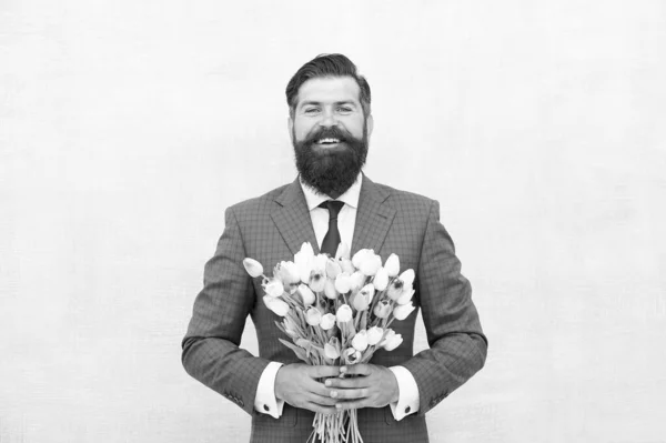 Hello summer. bearded man in formal suit greeting. happy valentines day. womens day gift tulips. spring flowers. Man with bouquet tulips. prepare for mothers day holiday. flower surprise for her