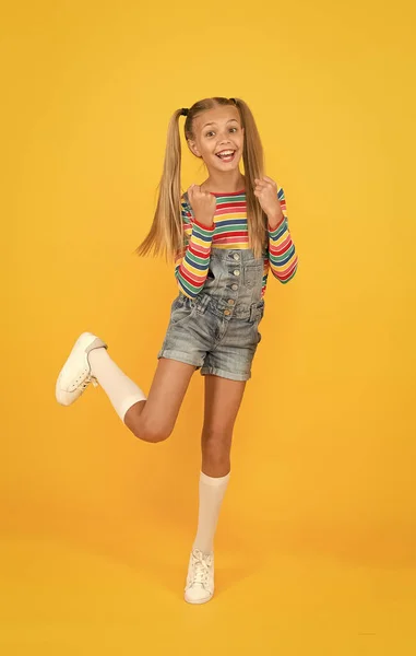 Miúdo despreocupado e engraçado. pequena beleza cabelo comprido. estilo vintage estudante. infância feliz. menina retro desfrutar de férias de verão. Criança pequena fundo amarelo. mercado de compras escolares — Fotografia de Stock