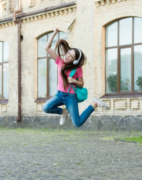 Energetica bambina che salta ballando ascoltando cuffie musicali, concetto di divertimento inarrestabile — Foto Stock