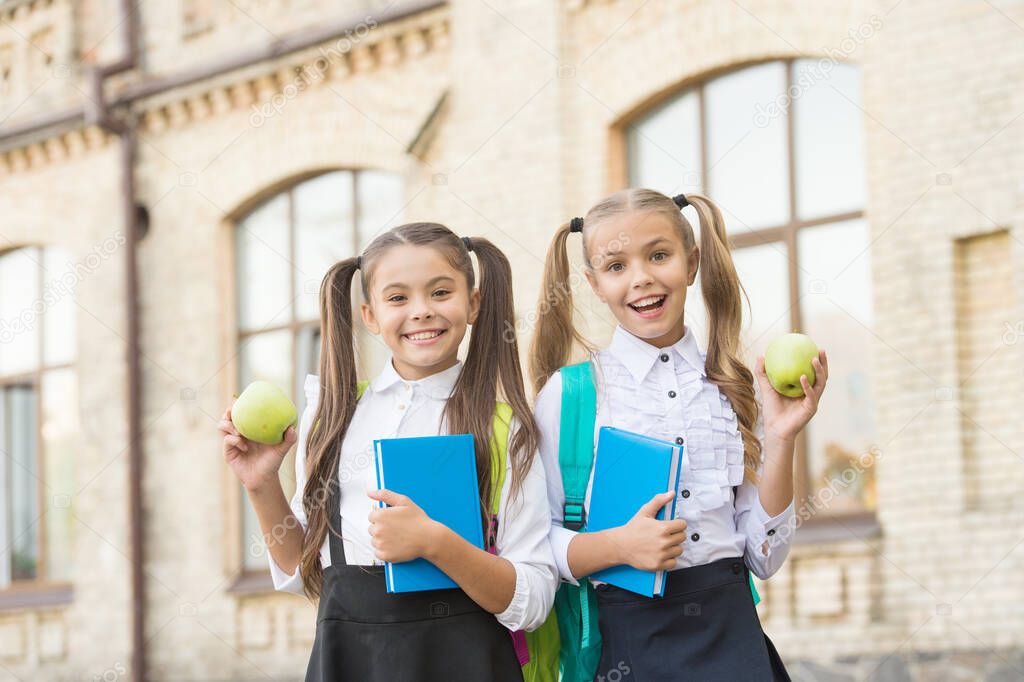 Students girls classmates with backpacks having school lunch, fresh vitamins concept