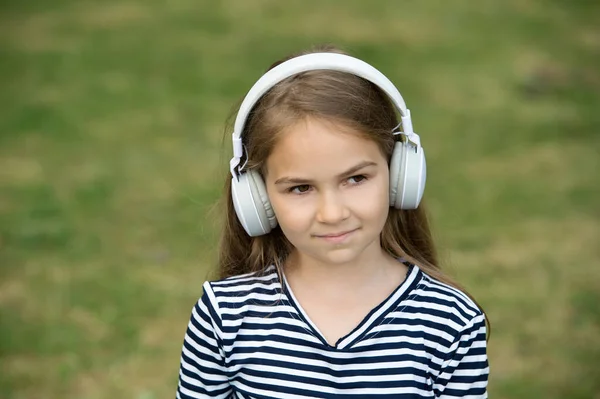 Enfrenta a música. Menina ouvir música ao ar livre. Pequena criança usa fones de ouvido tocando música. Nova tecnologia. Vida moderna. Férias. Diversão e entretenimento. Ouçam. — Fotografia de Stock