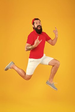 Güç ve enerji dolu. Hippi dansı atlayışı. Özgür hissediyorum. Koşan adam sarı arka plan. Kendini enerjik hissediyor. Rahatlama zamanı. Yaz tatili.