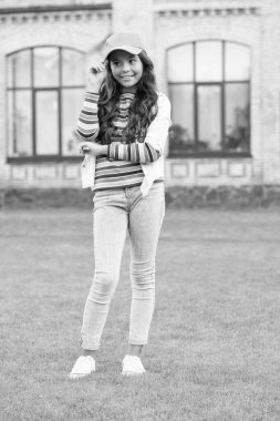 Çocuk dışarıda gülümsüyor. Güzellik ve moda. Yürüyen yeşil çimenler. Etrafta dolaşırdı. Liseli kız şapka takıyor. Gündelik tarz ve şapkalı bir genç. Çocukluk mutluluğu. Kıvırcık saçlı, şapkalı mutlu kız.