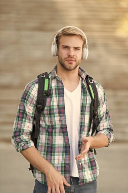 Düzgün bak. Ses kitabı konsepti. Eğitim teknolojisi. Öğrenciyim. Okul hayatı. Müziği dinle. Modern ve dijital gençlik. Şık bir adam. Üniversite öğrencisi kulaklıkları akıllı telefon. Çevrimiçi eğitim