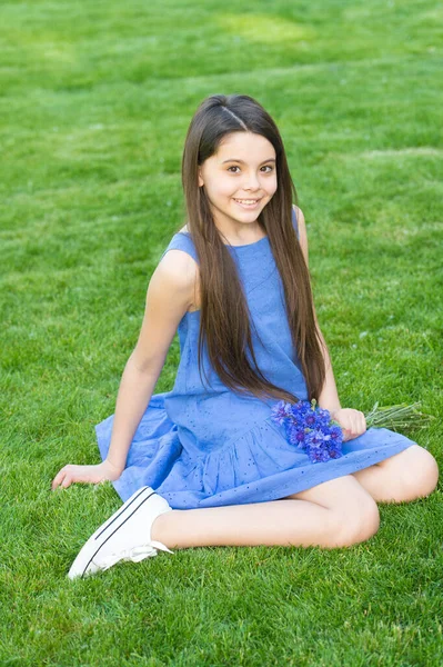 女の子の青いドレスは、新鮮なコーンフラワー、幸せな子供時代のコンセプトで緑のフィールドをリラックス — ストック写真