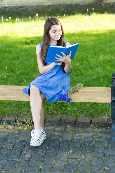 Mała szczęśliwa dziewczyna czyta książki na świeżym powietrzu słoneczny dzień, inteligentny pomysł hobby — Zdjęcie stockowe