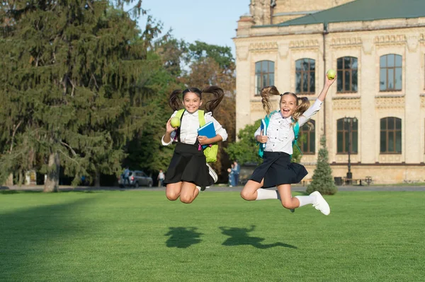 Unstoppable energy of little jumping schoolgirls school background, celebrate september concept — Stock Photo, Image