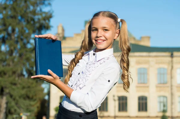 Excellent student girl study with school book outdoors, books shop concept