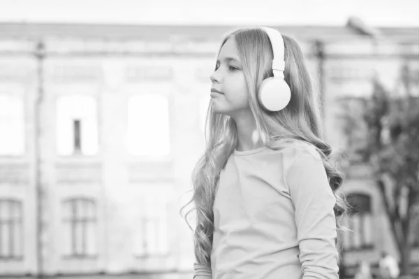 Słuchasz mnie uważnie? Małe dziecko słucha muzyki na świeżym powietrzu. Mały słuchacz nosi słuchawki. Słuchanie. Relaks i słuchanie. Współczesne życie. Poczuj muzykę słuchasz — Zdjęcie stockowe
